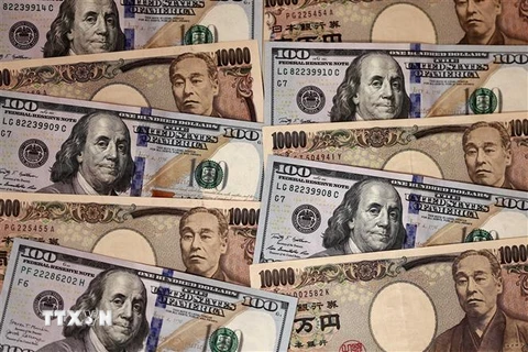 Tiền giấy mệnh giá 10.000 yen và 100 USD tại Tokyo, Nhật Bản. (Ảnh: AFP/TTXVN)