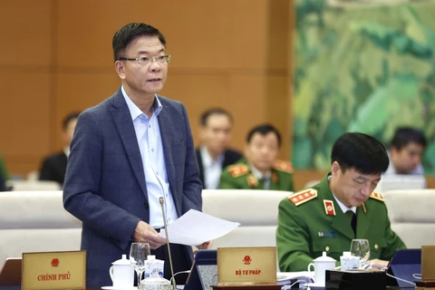 Bộ trưởng Bộ Tư pháp Lê Thành Long trình bày tờ trình. (Ảnh: Doãn Tấn/TTXVN)