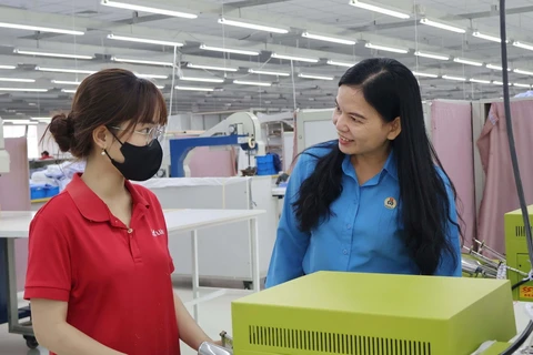 Phó Chủ tịch Liên đoàn Lao động tỉnh An Giang Phan Thị Diễm thăm hỏi công nhân tại Khu công nghiệp Bình Hòa, huyện Châu Thành. (Ảnh: Công Mạo/TTXVN)