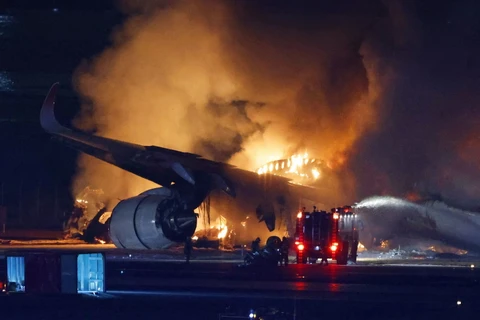 Lính cứu hỏa nỗ lực dập lửa máy bay chở khách bị cháy sau va chạm với máy bay của Lực lượng bảo vệ bờ biển Nhật Bản, tại Sân bay Haneda ở Tokyo, tối 2/1/2024. (Ảnh: Kyodo/TTXVN)