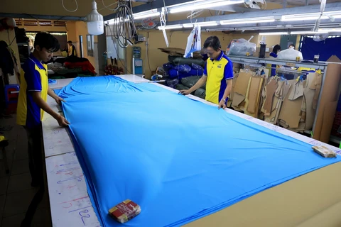 Cắt may tại xưởng gia công dệt may xuất khẩu Công ty TNHH May mặc Dony, xã Vĩnh Lộc A, huyện Bình Chánh, Thành phố Hồ Chí Minh. (Ảnh: Hồng Đạt/TTXVN)