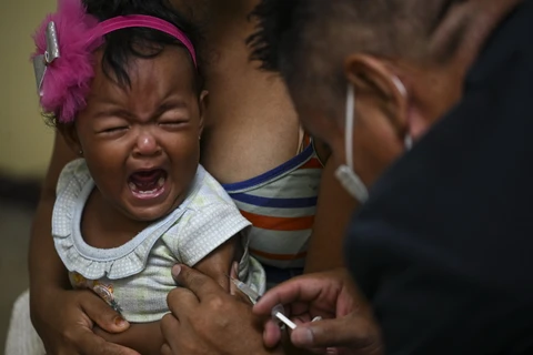 Nhân viên y tế tiêm vaccine ngừa bệnh sởi cho trẻ em tại Caracas, Venezuela. (Ảnh: AFP/TTXVN)