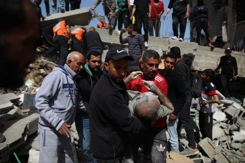 Người dân chuyển nạn nhân bị thương sau cuộc không kích của Israel xuống Dải Gaza ngày 31/3/2024. (Ảnh: THX/TTXVN)