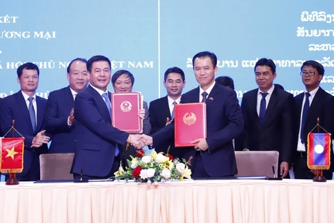Bộ trưởng Bộ Công Thương Nguyễn Hồng Diên và Bộ trưởng Bộ Công Thương Lào Malaithong Kommasith ký Hiệp định thương mại Việt Nam-Lào. (Ảnh: Phạm Kiên/TTXVN)