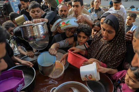 Người dân chờ nhận thức ăn cứu trợ tại thành phố Rafah, Dải Gaza, ngày 30/3/2024. (Ảnh: THX/TTXVN)