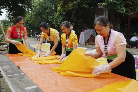 Bánh khẩu xén sau khi dát mỏng được mang đi phơi khô vừa phải rồi cắt. (Ảnh: Xuân Tư/TTXVN)