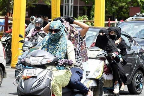Người dân quấn khăn tránh nắng nóng khi di chuyển trên đường tại Bhopal, Ấn Độ ngày 27/5/2024. (Ảnh: ANI/TTXVN)