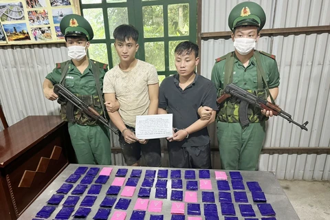 Hai đối tượng cùng tang vật ma túy bị lực lượng biên phòng Sơn La bắt giữ. (Ảnh: TTXVN phát)