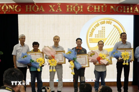 Lãnh đạo Thành phố Hồ Chí Minh trao Bằng khen của Chủ tịch UBND Thành phố Hồ Chí Minh cho các cá nhân tiêu biểu. (Ảnh: Tiến Lực/TTXVN)