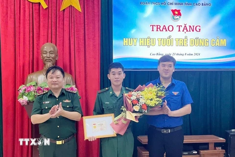 Phó Bí thư Thường trực Tỉnh đoàn, Phó Chủ tịch Hội Liên hiệp thanh niên Việt Nam tỉnh Cao Bằng Hà Ngọc Huy trao tặng Huy hiệu “Tuổi trẻ dũng cảm” cho Binh nhất Lý Văn Vũ. (Ảnh: TTXVN phát)