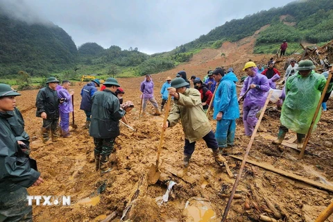 Lực lượng cứu hộ, vẫn đang tích cực đào bới đất tìm kiếm nạn nhân mất tích ở địa điểm xóm Lũng Lỳ, xã Ca Thành. (Ảnh: Quốc Đạt/TTXVN)