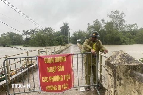 Lực lượng chức năng lập rào chắn và biển cảnh báo người dân không di chuyển qua khu vực nguy hiểm tại thôn Liệp Mai, xã Ngọc Liệp, huyện Quốc Oai. (Ảnh: Vũ Sinh/TTXVN)