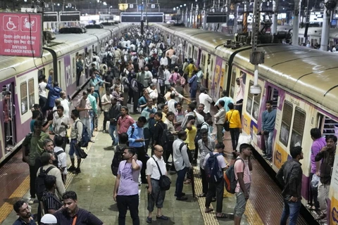 Người đi làm bị mắc kẹt tại Chhatrapati Shivaji Terminus trong trận mưa lớn ở Mumbai, Ấn Độ ngày 25/9. (Ảnh: AP)