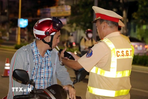 Cảnh sát Giao thông kiểm tra nồng độ cồn với người điều khiển phương tiện giao thông. (Ảnh: TTXVN phát)