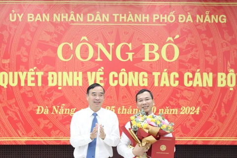 Chủ tịch UBND thành phố Lê Trung Chinh (trái) trao quyết định, tặng hoa chúc mừng tân Giám đốc Sở Nội vụ kiêm Chủ tịch UBND huyện Hoàng Sa, ông Nguyễn Hữu Lợi. (Ảnh: Báo Đà Nẵng)