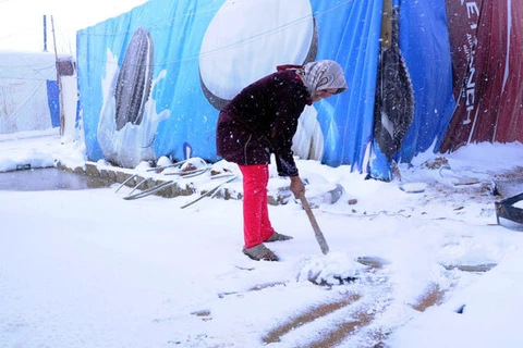 Người tị nạn Syria dọn tuyết tại trại ở gần Liban (Nguồn: AFP)