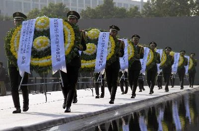 Binh sĩ Trung Quốc đặt hoa tại lễ tưởng niệm các nạn nhân vụ thảm sát Nam Kinh tại Bảo tàng tưởng niệm cuộc thảm sát Nam Kinh. THX-TTXVN