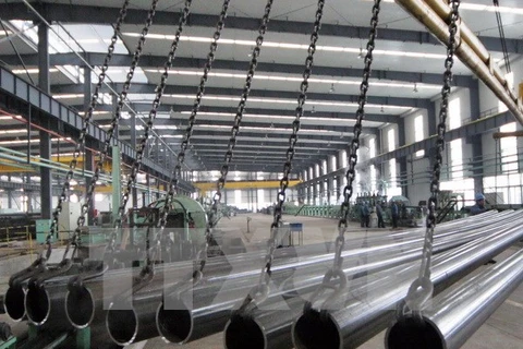 Công nhân kiểm tra ống thép inox chất lượng cao tại nhà máy ở huyện Ganyu, tỉnh Giang Tô, miền đông Trung Quốc. (Nguồn: THX/TTXVN)