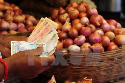Người dân mua bán hành tại khu chợ ở Mumbai. (Nguồn: AFP/TTXVN)