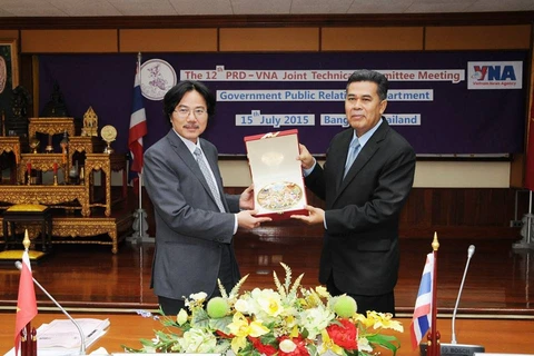 Phó Tổng Giám đốc Thông tấn xã Việt Nam Ngô Hà Thái (trái) và Phó Tổng Giám đốc PRD Charoon Chaison trao quà lưu niệm. Ảnh: Quang Thuận-Phóng viên TTXVN tại Thái Lan 