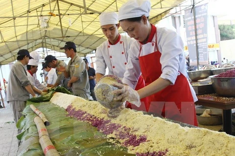 Các nhân viên Khách sạn Sài Gòn-Đông Hà chuẩn bị gạo, đỗ để gói bánh tét dâng cúng tại thành cổ Quảng Trị năm 2014. (Ảnh: Hồ Cầu/TTXVN)