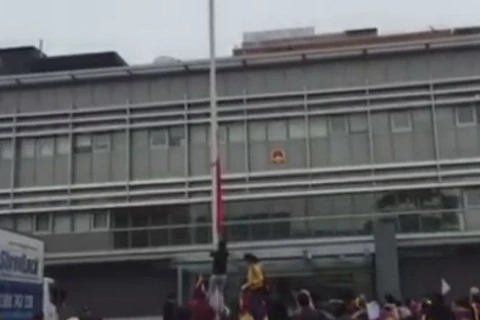 Những người biểu tình kéo lá cờ Trung Quốc xuống tại Lãnh sự quán Trung Quốc ở Sydney. (Nguồn: abc.net.au)