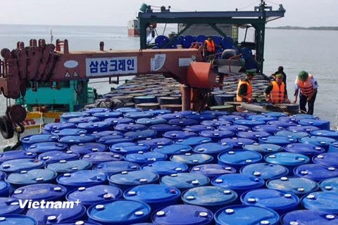 Lực lượng chức năng kiểm tra chiếc sà lan chở gần 200.000 lít dầu không rõ nguồn gốc. (Ảnh: Công Trí/Vietnam+)
