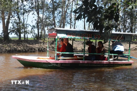Những du khách đầu tiên tham quan Vườn quốc gia Tràm Chim bằng tàu chạy từ năng lượng mặt trời. (Ảnh: Huỳnh Phúc Hậu/TTXVN) 