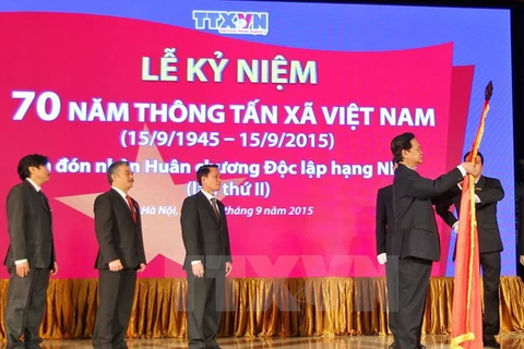 Thủ tướng Nguyễn Tấn Dũng gắn Huân chương Độc lập hạng Nhất lên Cờ truyền thống của Thông tấn xã Việt Nam. (Ảnh: Đức Tám/TTXVN)
