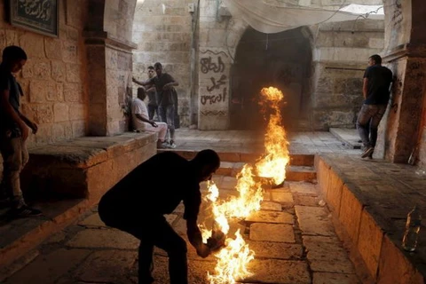 Một người Palestine đốt lửa khi đụng độ với cảnh sát Israel tại thánh đường Al-Aqsa. (Nguồn: Reuters)