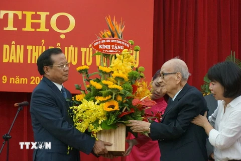 Bí Thư Thành ủy Hà Nội Phạm Quang Nghị tặng hoa giáo sư Vũ Khiêu. (Ảnh: Đinh Thị Thuận/TTXVN)