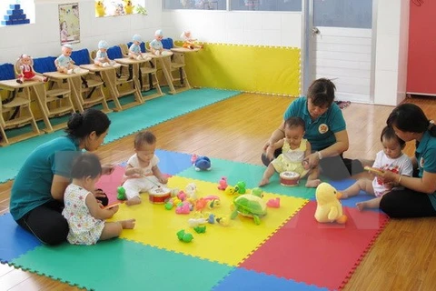 Giáo viên Trường Mầm non Hoa Phương Đỏ, quận Gò Vấp, chăm sóc trẻ từ 6-18 tháng tuổi. (Ảnh: Phương Vy/TTXVN)