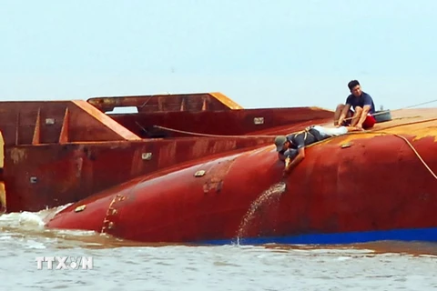 Lực lượng cứu hộ triển khai hàn cắt, phá lớp vỏ tàu để tìm kiếm 4 người còn mất tích. (Ảnh: Mạnh Linh/TTXVN) 
