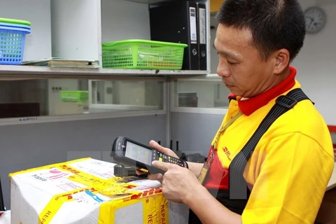 Nhân viên DHL dùng máy quét mã vạch không dây để quản lý hàng hóa. (Ảnh: Minh Tú/TTXVN)