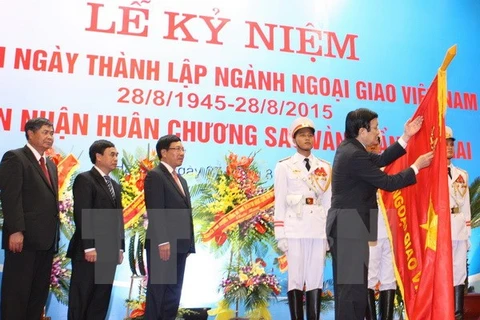 Chủ tịch nước Trương Tấn Sang gắn Huân chương Sao Vàng lên là cờ truyền thống của ngành ngoại giao Việt Nam. (Ảnh: Thống Nhất/TTXVN)