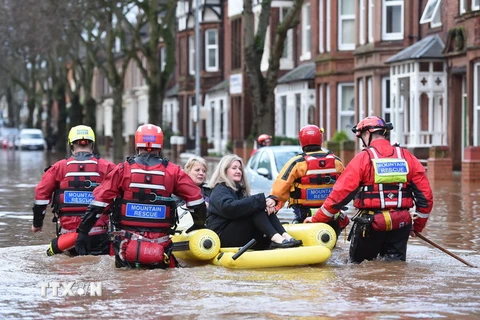 Nhân viên cứu hộ sơ tán người dân khỏi các khu vực ngập lụt ở Carlisle ngày 6/12. (Nguồn: AFP/TTXVN)