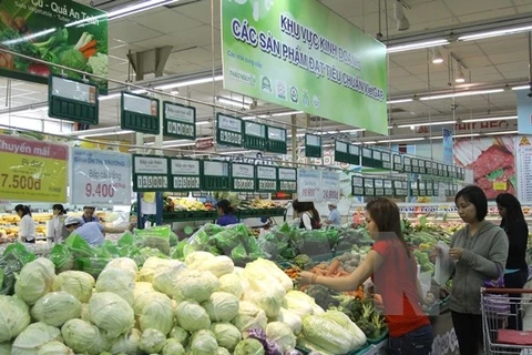 Người tiêu dùng lựa chọn sản phẩm rau, củ, quả đạt tiêu chuẩn VietGap tại siêu thị. (Ảnh: Thanh Vũ/TTXVN)