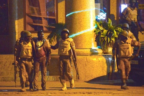 Binh sỹ Burkina Faso đưa một người bị thương rời khỏi khách sạn Splendid. (Nguồn: AFP)