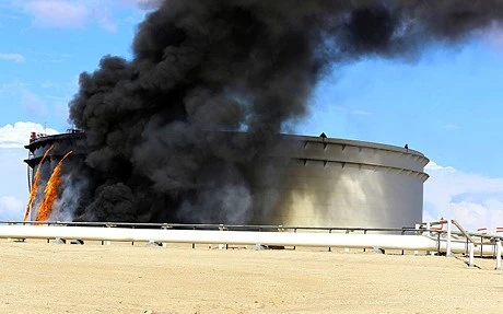 Khói bốc lên từ một cơ sở lọc dầu ở Libya sau khi trúng rocket. (Nguồn: Telegraph)