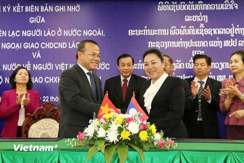 Lãnh đạo Ủy ban về người Việt Nam ở nước ngoài và Ủy ban liên lạc người Lào ở nước ngoài ký biên bản hợp tác giai đoạn 2016-2020. (Ảnh: Phạm Kiên/Vietnam+)
