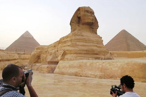 Tượng Nhân sư bên cạnh kim tự tháp Menkaure (phải) và Khafre (trái) tại Giza, ngoại ô thủ đô Cairo ngày 9/11. (Nguồn: Kyodo/TTXVN)