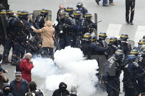 Người biểu tình đụng độ với cảnh sát chống bạo động trong cuộc tuần hành phản đối dự luật lao động sửa đổi ở Pháp ngày 28/4. (Nguồn: AFP/TTXVN)