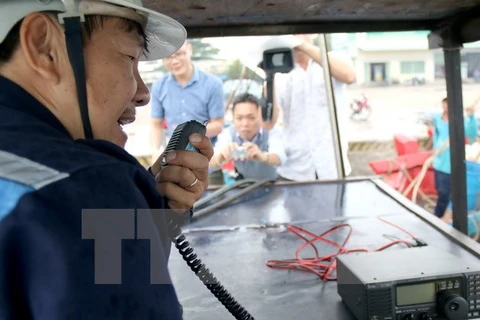 Kiểm tra thiết bị thông tin liên lạc lắp trên tàu cho ngư dân. (Ảnh: Nguyễn Thanh/TTXVN)