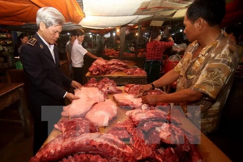 Nhân viên Thú y kiểm tra sản phẩm thịt lợn tại một hộ kinh doanh. (Ảnh: Vũ Sinh/TTXVN)
