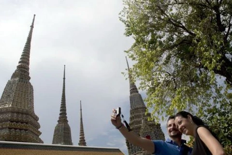 Khách du lịch chụp ảnh lưu niệm tại ngôi chùa Wat Pho ở Bangkok, Thái Lan. (Nguồn: AP)