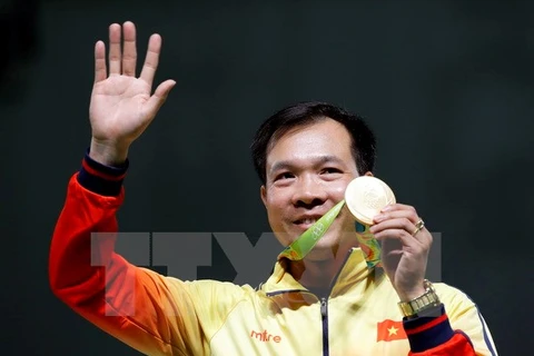 Xạ thủ Hoàng Xuân Vinh cùng tấm huy chương Vàng lịch sử. (Nguồn: EPA/TTXVN)