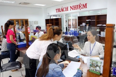Hướng dẫn người dân giải quyết thủ tục hành chính tại khu vực giao dịch một cửa điện tử ở Trung tâm hành chính Đà Nẵng. (Ảnh: Trần Lê Lâm/TTXVN)