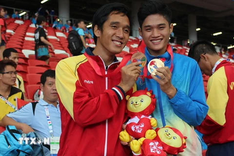 Vận động viên Nguyễn Ngọc Hiệp (áo đỏ) giành huy chương đồng chạy 400m tại ASEAN Para Games lần thứ 8. (Nguồn: TTXVN) 