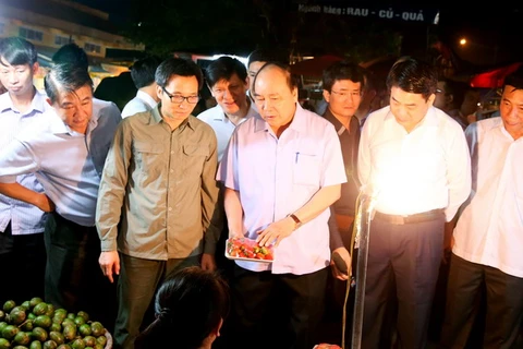 Thủ tướng Nguyễn Xuân Phúc đi kiểm tra vệ sinh an toàn thực phẩm tại chợ đầu mối Long Biên. (Ảnh: Thống Nhất/TTXVN) 