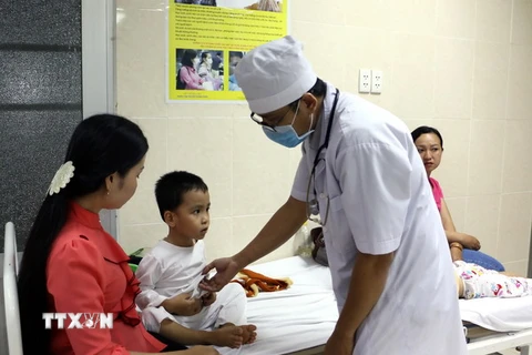 Bác sỹ thăm khám cho trẻ được cấp cứu tại Bệnh viện Đa khoa huyện Tam Bình. (Ảnh: Phạm Minh Tuấn/TTXVN)